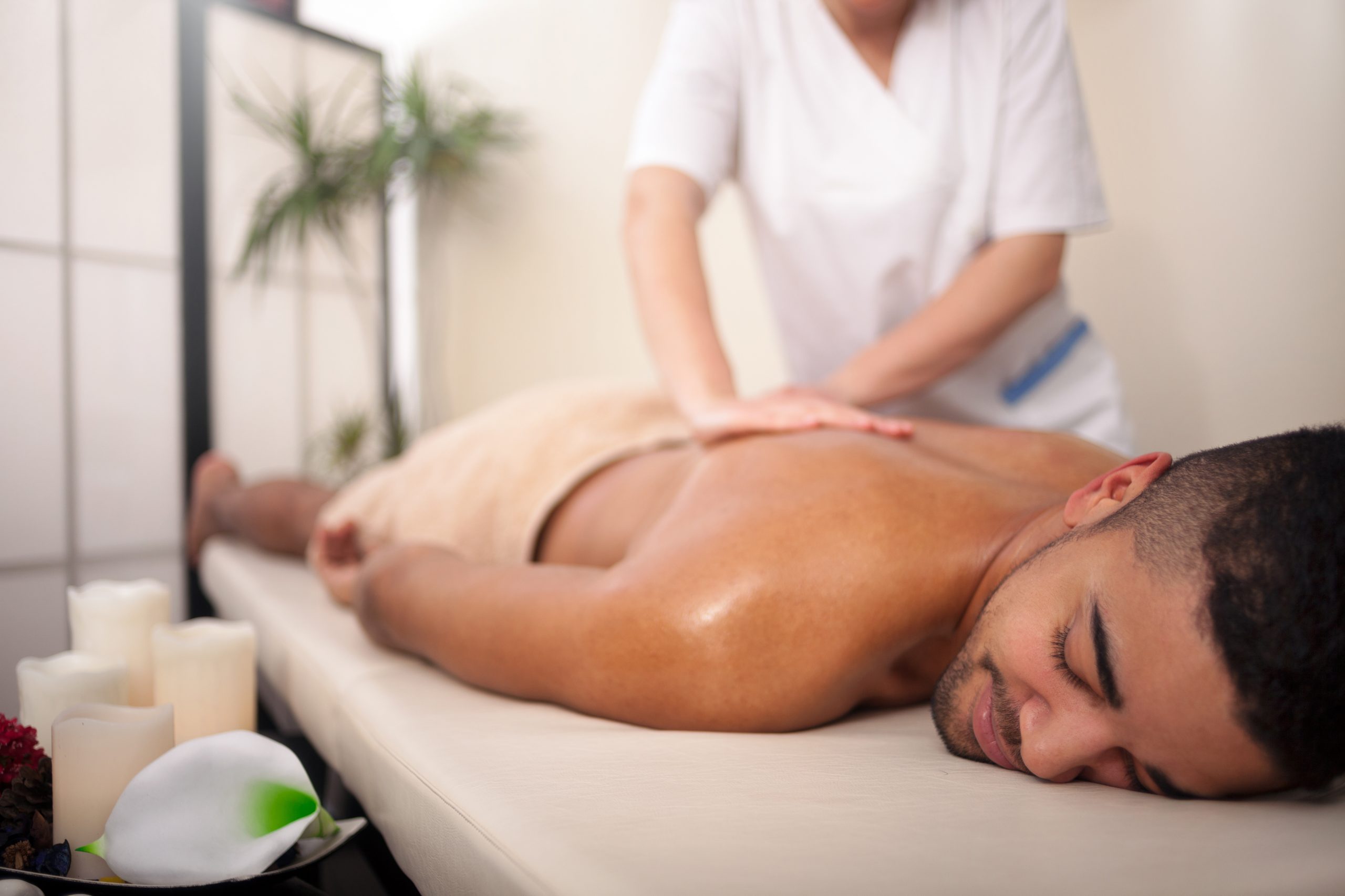 massage therapist works on guys lower body